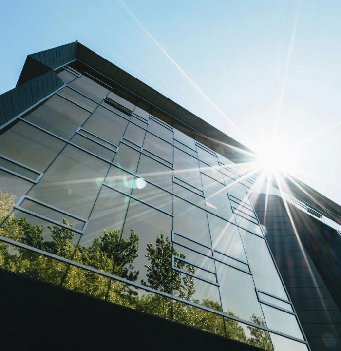 pexels-photo-305833-305833 Low angle view of a modern skyscraper with reflections and sun flare, emphasizing contemporary architecture.